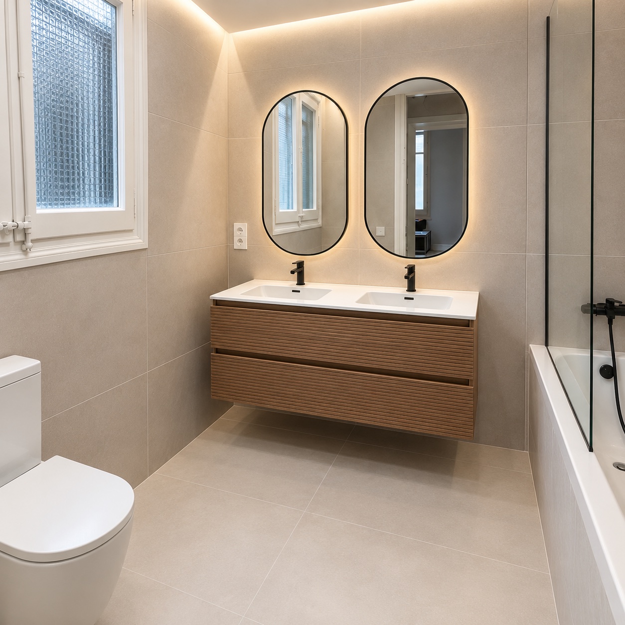 Baño reformado en Plaza Catalunya con doble lavabo, espejo antivaho retroiluminado y bañera